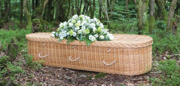a coffin with a white flower bouquet on it